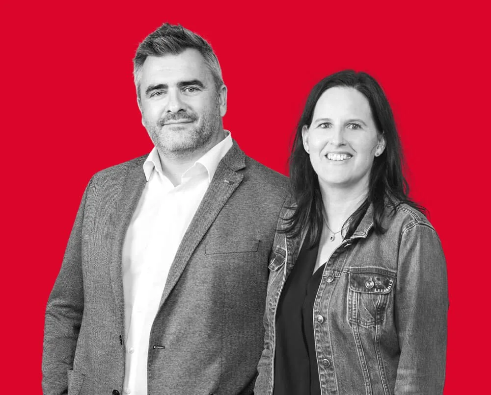 Christine und Markus Aschaber vor rotem Hintergrund