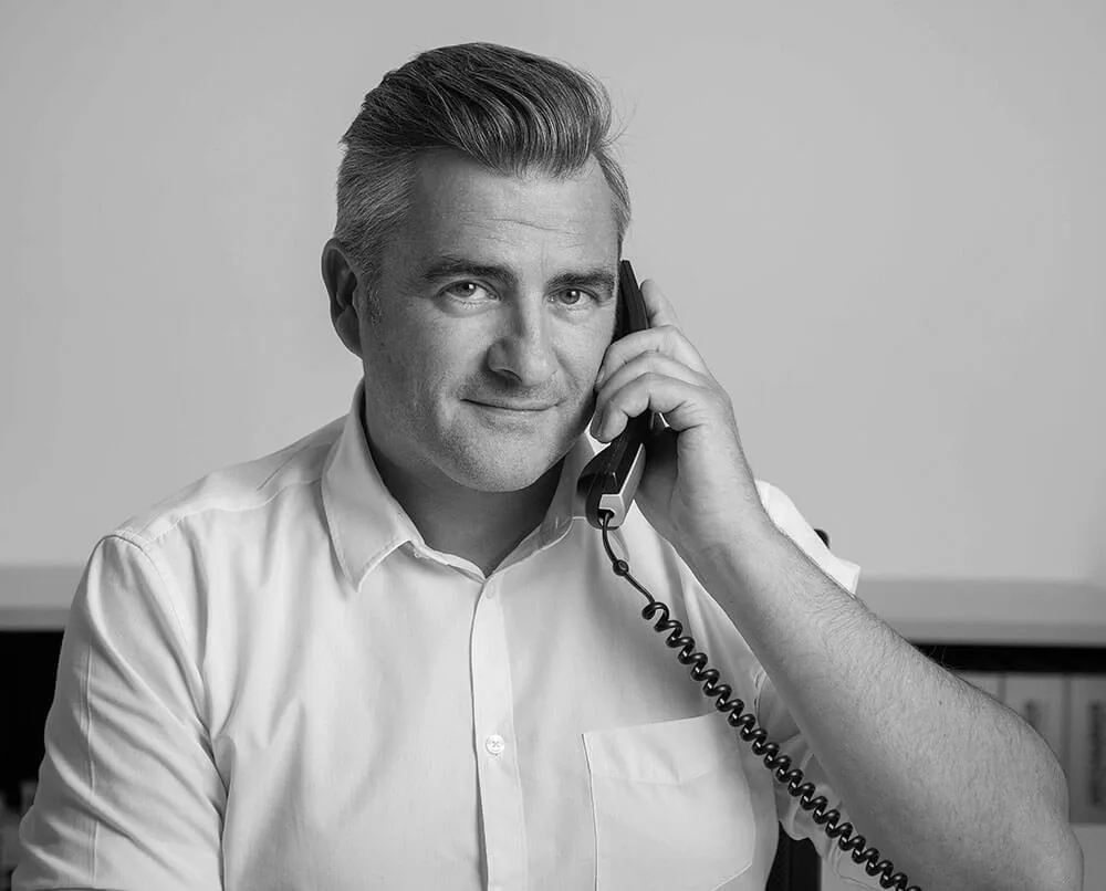 Markus Aschaber am Telefon, schwarz-weiß